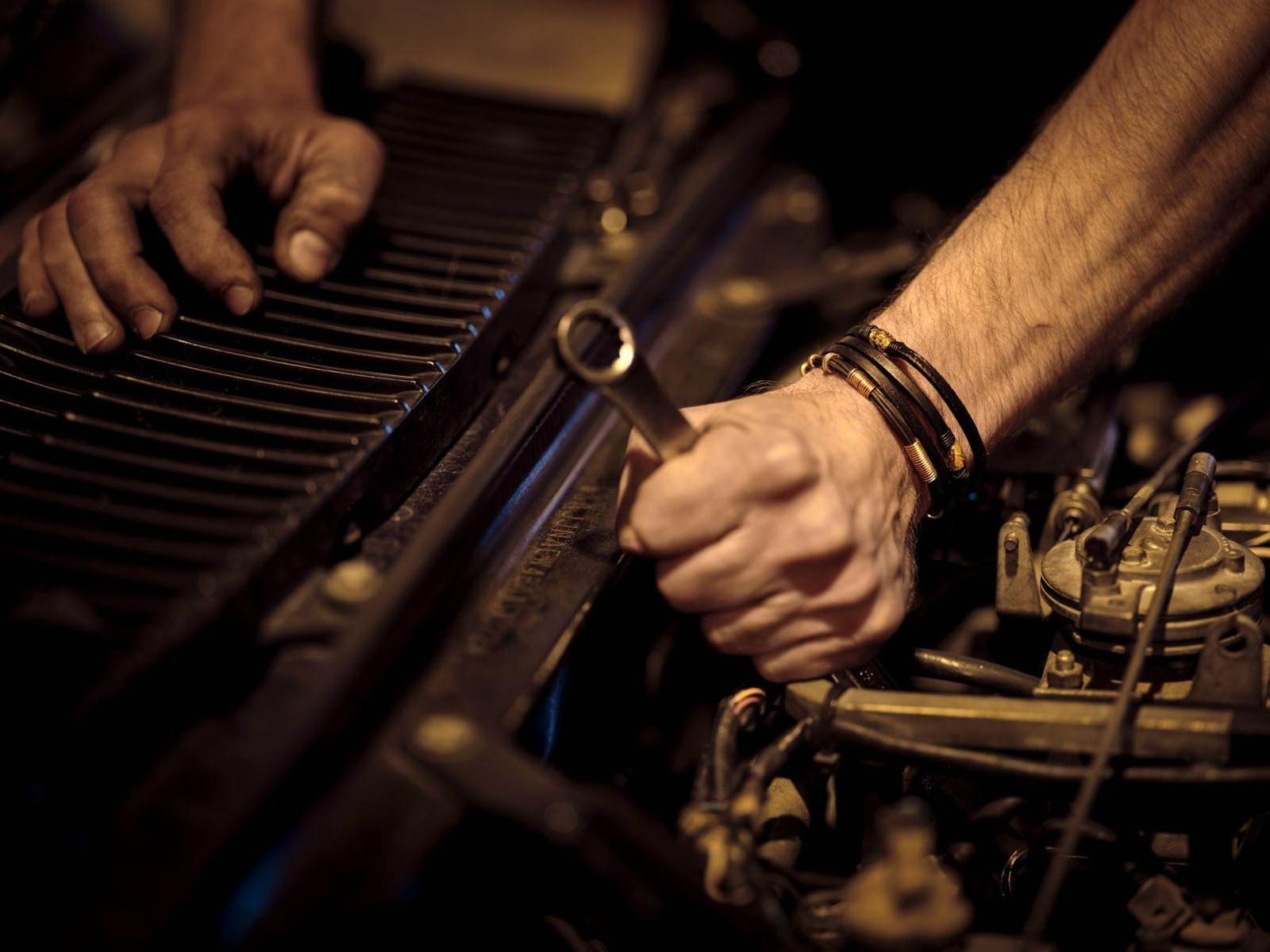 Technician working on an engine with a wrench